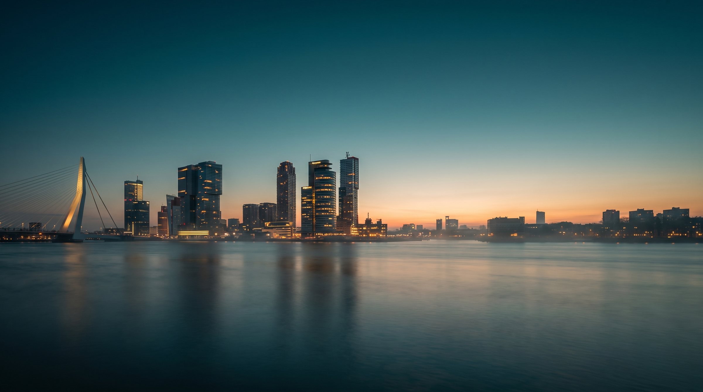Skyline van Rotterdam met de Erasmusbrug in het blauwe uur